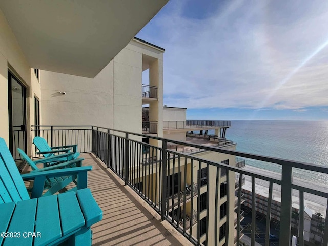 balcony with a water view and a beach view