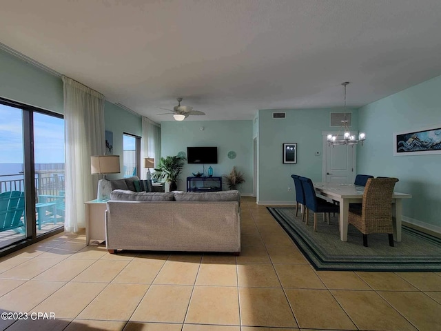 tiled living room featuring ceiling fan with notable chandelier