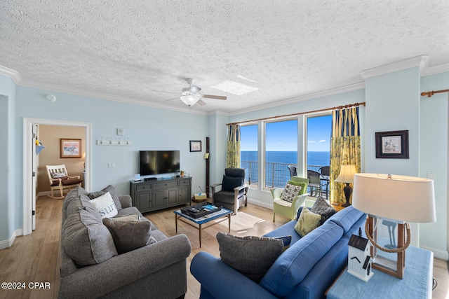 8715 Surf Dr Unit 1402B, Panama City, FL 32408 - living area with light wood-style flooring, ornamental molding, a ceiling fan, baseboards, and a textured ceiling