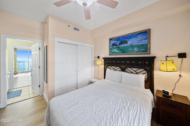 8715 Surf Dr Unit 1402B, Panama City, FL 32408 - bedroom featuring light wood-style floors, a closet, baseboards, and ceiling fan