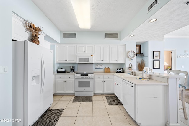 8715 Surf Dr Unit 1402B, Panama City, FL 32408 - kitchen with white appliances, a sink, a peninsula, white cabinets, and a textured ceiling