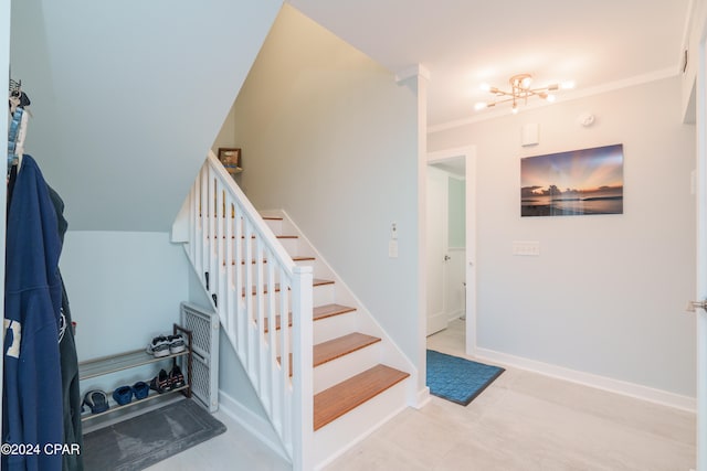 stairway with crown molding and a chandelier