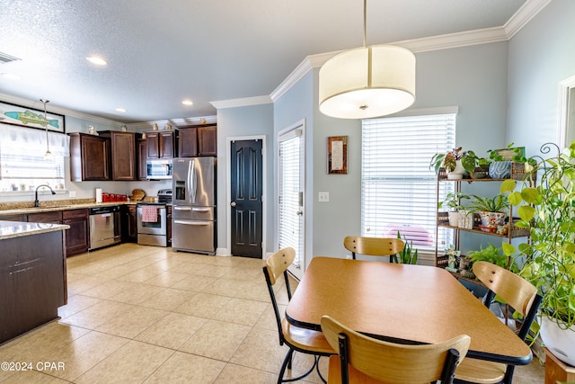 tiled dining space with crown molding and a textured ceiling