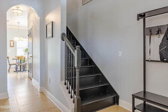 stairway featuring tile patterned floors and ornamental molding