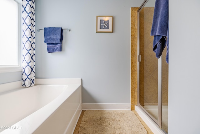 bathroom featuring shower with separate bathtub