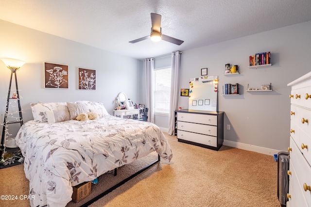 bedroom featuring a textured ceiling, light colored carpet, and ceiling fan