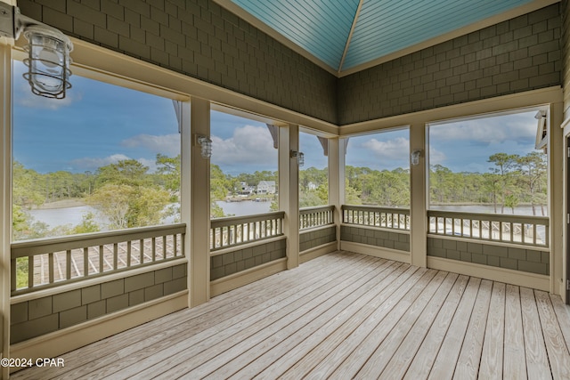 unfurnished sunroom featuring a water view and vaulted ceiling