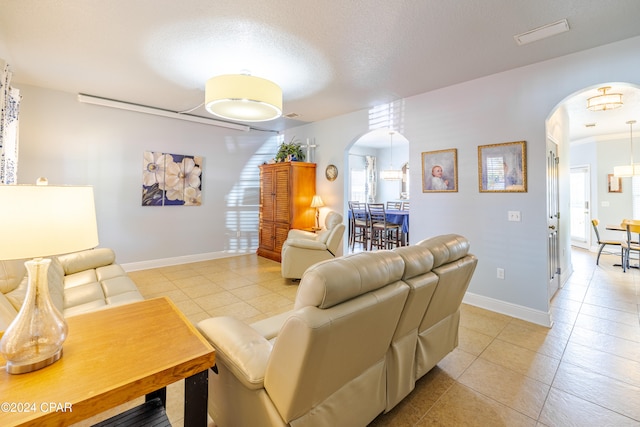 tiled living room featuring a textured ceiling and ornamental molding