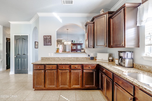 kitchen featuring light stone counters, light tile patterned floors, and crown molding