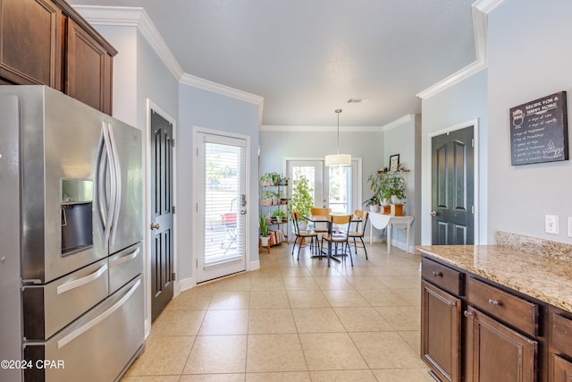 kitchen with stainless steel refrigerator with ice dispenser, pendant lighting, light stone counters, and crown molding