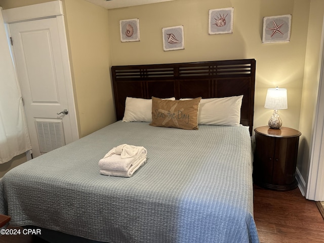 bedroom with dark hardwood / wood-style flooring