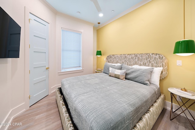 bedroom featuring hardwood / wood-style flooring, ceiling fan, and crown molding