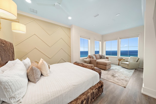 bedroom with a water view, ceiling fan, and dark hardwood / wood-style floors