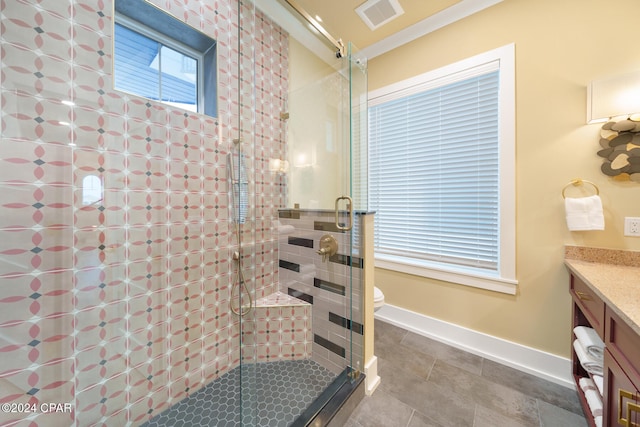 bathroom featuring tile patterned flooring, vanity, toilet, and a shower with shower door