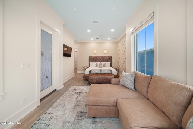 bedroom with ornamental molding and light hardwood / wood-style floors