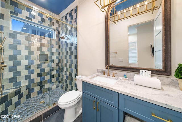 bathroom with tile patterned floors, vanity, toilet, and tiled shower