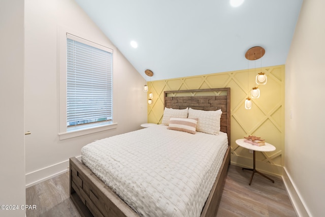 bedroom with lofted ceiling and hardwood / wood-style flooring