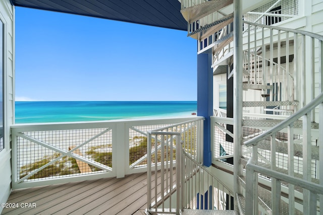 balcony featuring a water view and a beach view