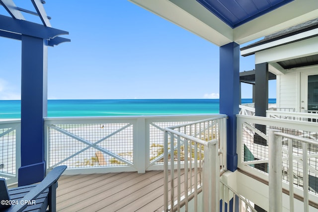 balcony featuring a view of the beach and a water view