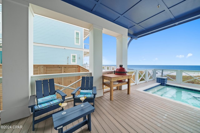 wooden deck featuring a water view and a swimming pool