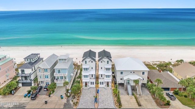 drone / aerial view featuring a beach view and a water view