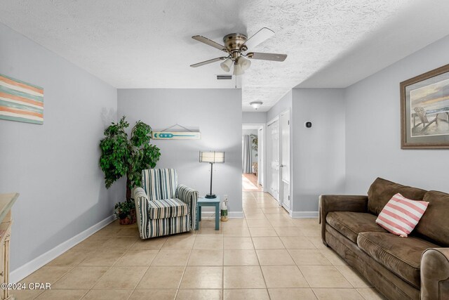 tiled living room featuring a textured ceiling and ceiling fan