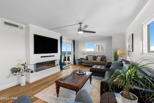 living room with crown molding, ceiling fan, and wood-type flooring