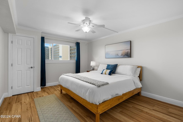 bedroom featuring ceiling fan, ornamental molding, and light hardwood / wood-style flooring