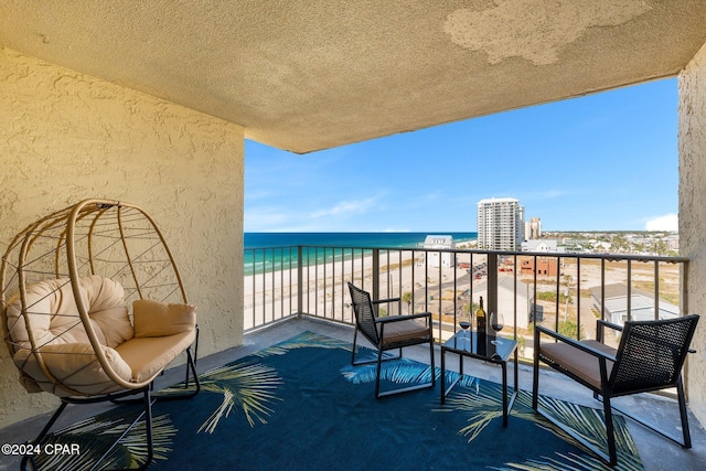 balcony with a water view and a beach view