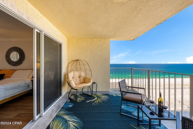 balcony with a water view and a beach view