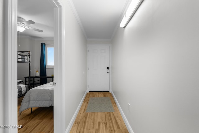 corridor with crown molding and light hardwood / wood-style flooring