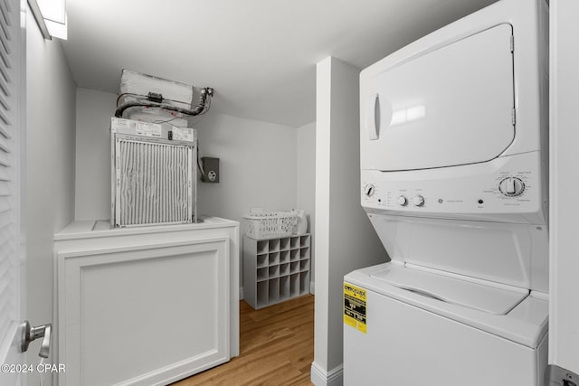 washroom with stacked washer and clothes dryer and light wood-type flooring