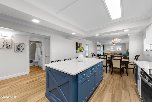 kitchen with a center island, electric range oven, a notable chandelier, blue cabinets, and light hardwood / wood-style floors