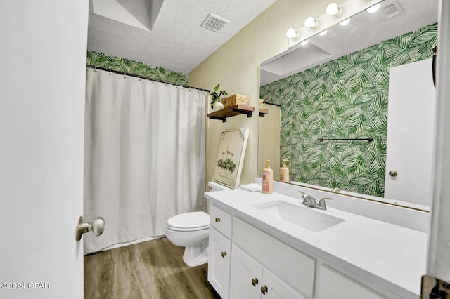 bathroom with hardwood / wood-style floors, vanity, toilet, a textured ceiling, and a shower with curtain