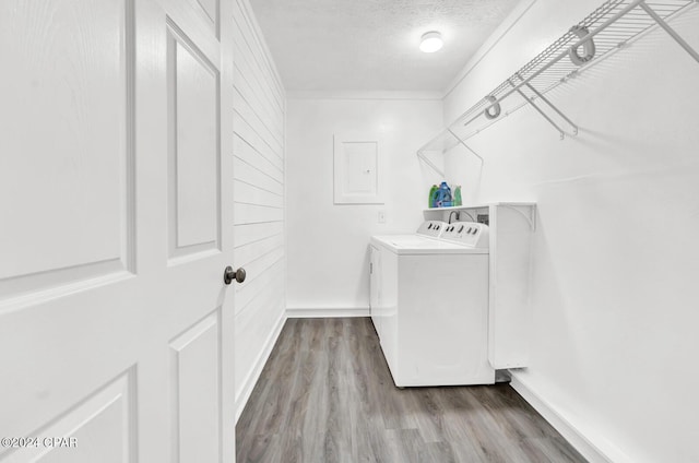 clothes washing area with separate washer and dryer, crown molding, light hardwood / wood-style flooring, and a textured ceiling