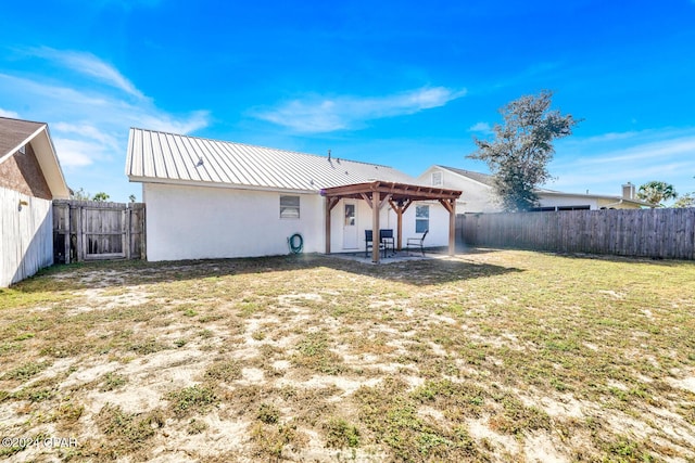 back of house with a yard and a pergola