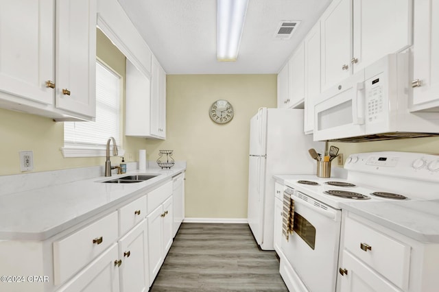 kitchen with dark hardwood / wood-style flooring, sink, white appliances, and white cabinets