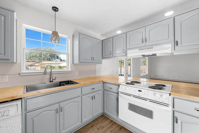 kitchen with white appliances, a textured ceiling, sink, and a wealth of natural light