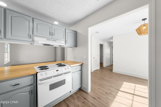 kitchen with light hardwood / wood-style floors, wood counters, a textured ceiling, and electric range