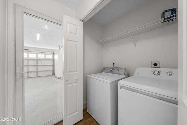 laundry room with hardwood / wood-style floors, a textured ceiling, and washer and dryer