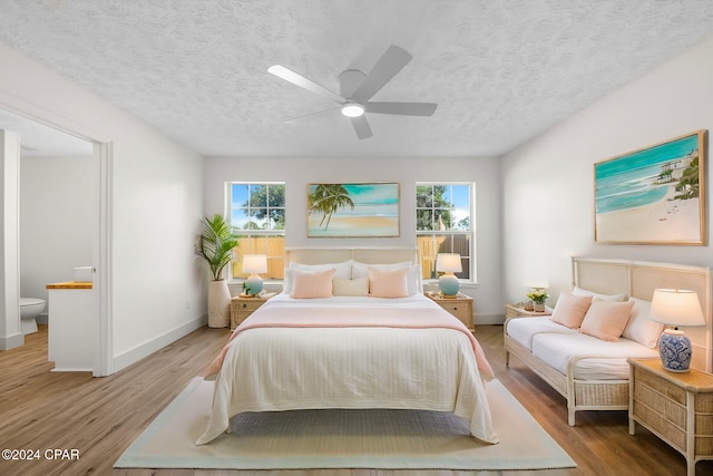 living room with a healthy amount of sunlight, light wood-type flooring, lofted ceiling, and a textured ceiling