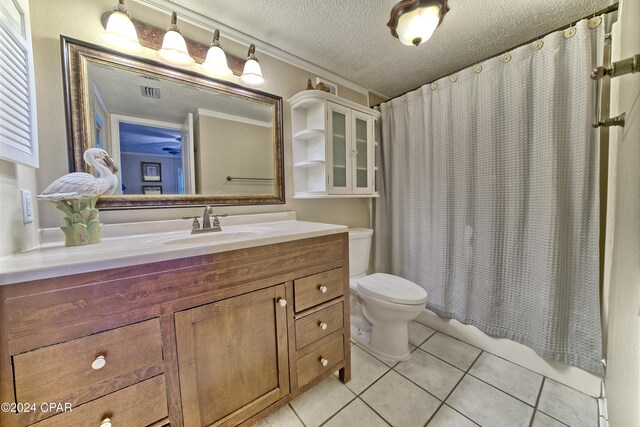 bathroom featuring tile patterned floors, vanity, a textured ceiling, curtained shower, and toilet