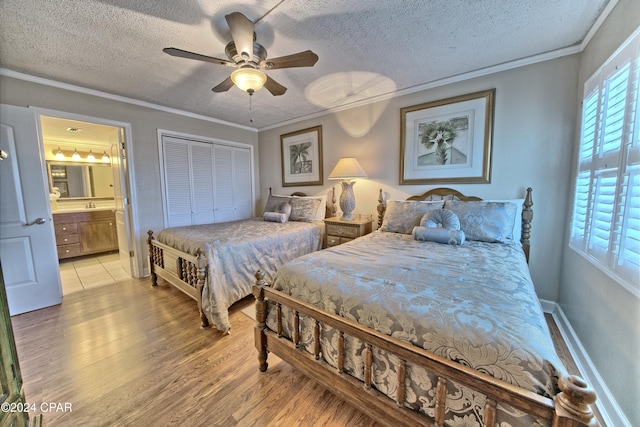 bedroom featuring a closet, ceiling fan, light hardwood / wood-style floors, and crown molding