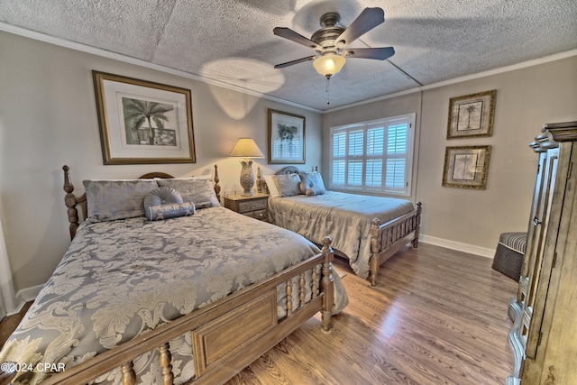 bedroom featuring hardwood / wood-style flooring, ceiling fan, a textured ceiling, and crown molding