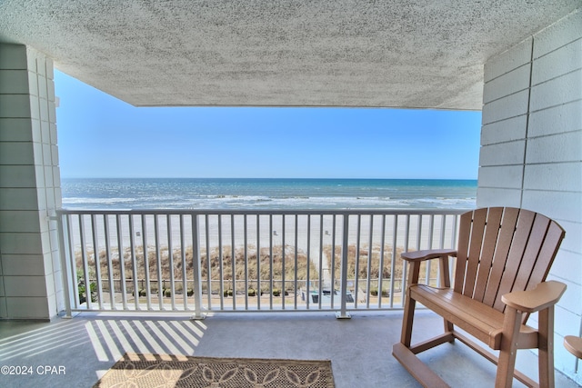 balcony featuring a water view and a beach view