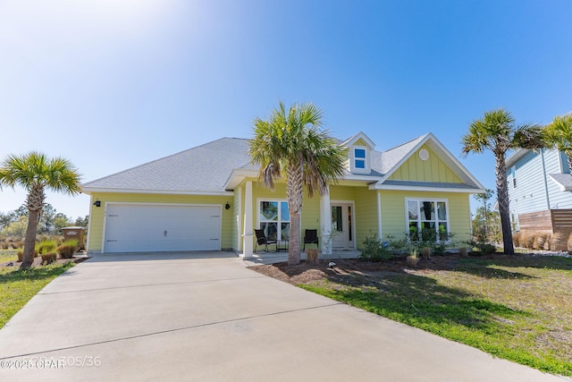 view of front of home featuring board and batten siding, concrete driveway, a garage, and a front yard