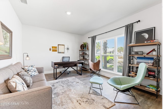 office space featuring visible vents, baseboards, and wood finished floors