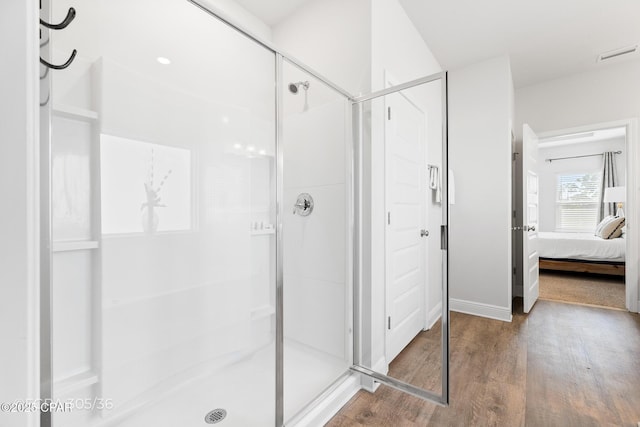 full bath with visible vents, connected bathroom, a shower stall, and wood finished floors