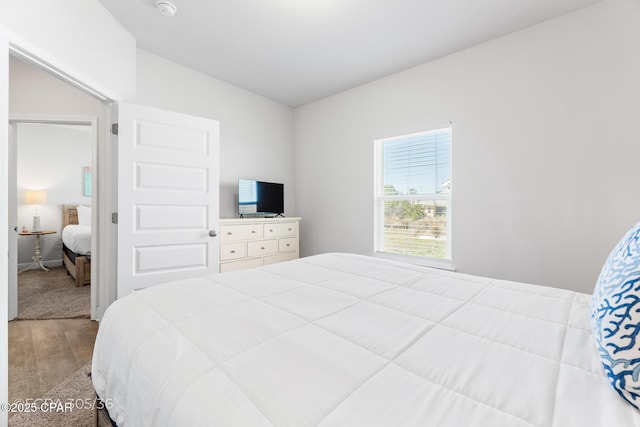 bedroom with baseboards and wood finished floors