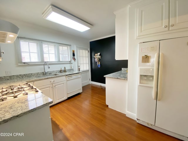 kitchen with light stone counters, white cabinetry, sink, light hardwood / wood-style floors, and white appliances